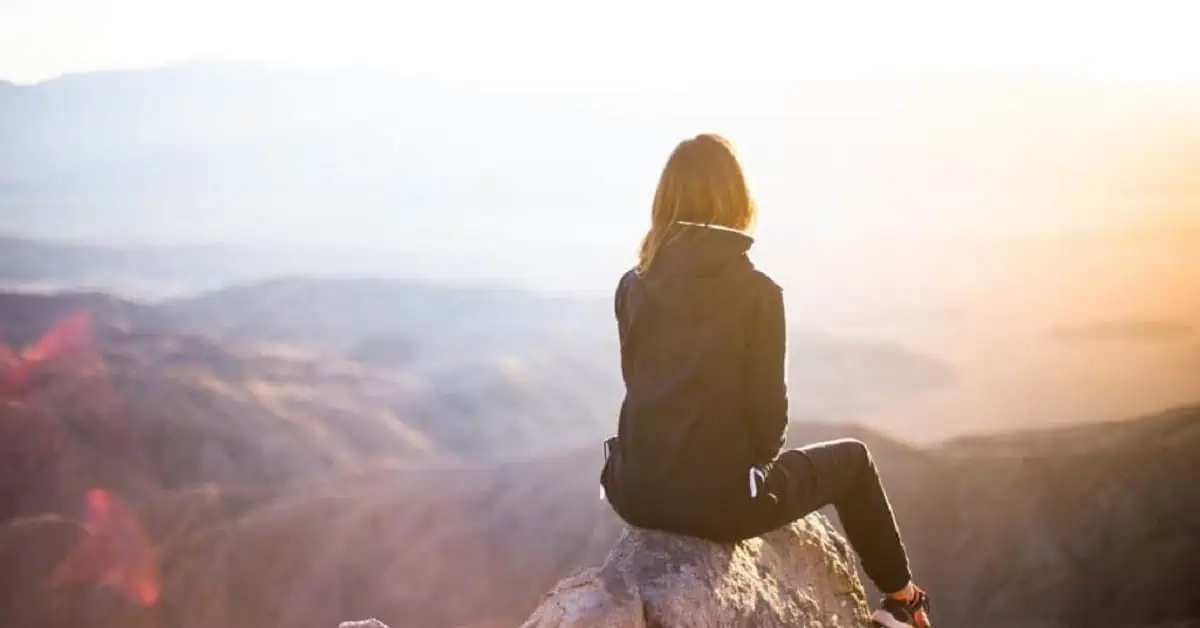 Woman Sitting on Mountain Top