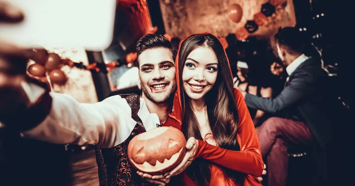 Couple Celebrating Halloween - Man and Woman Dressed as Vampires Taking a Selfie