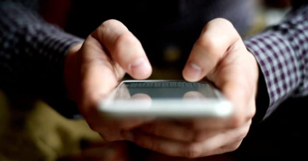 Man Holding Smartphone and Texting
