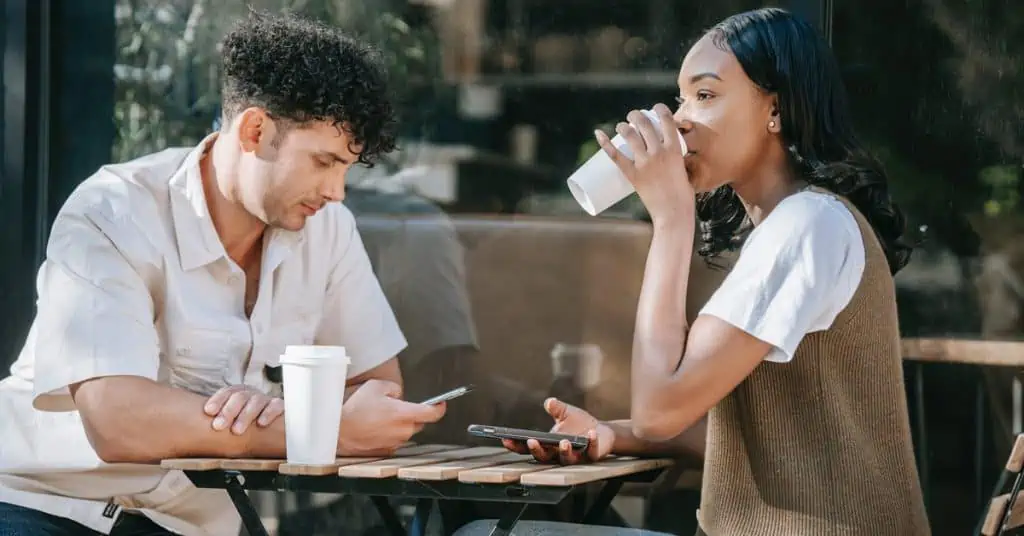Man and Woman Seated Having Coffee and Looking at Their Phones - Bad Date