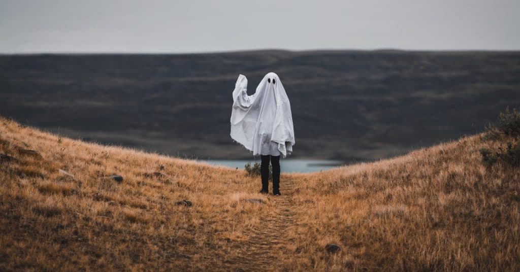 Person Dressed as a Sheet Ghost Standing in a Hill