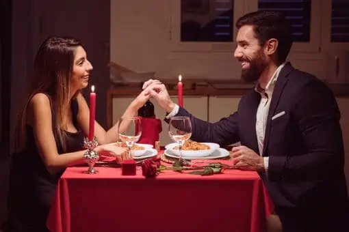 Man and woman celebrating New Years by having romantic dinner at home