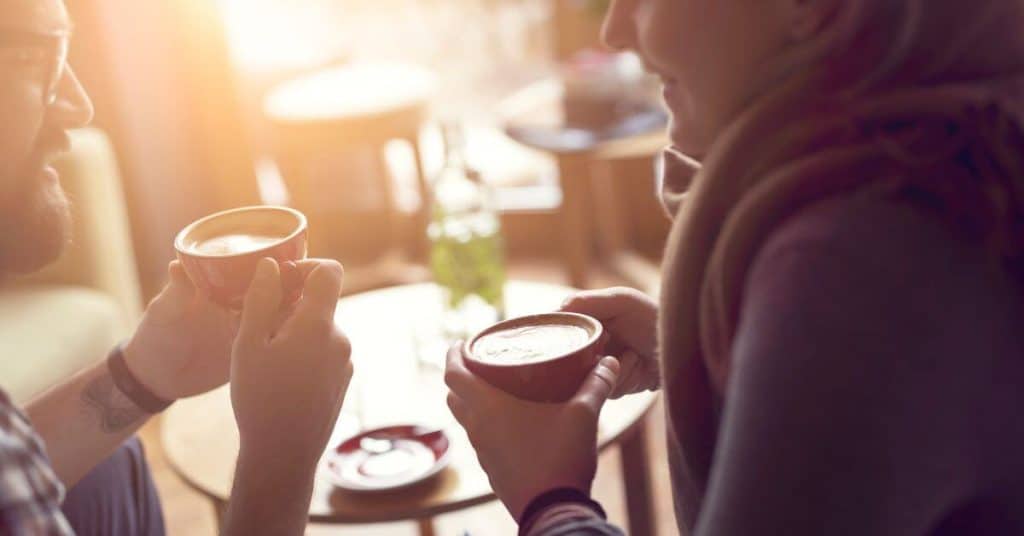 Man and woman participating in a dawn date by getting coffee in the morning together