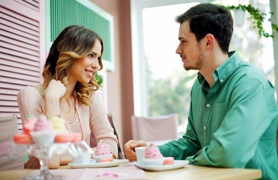 Woman making eye contact and smiling at man, showing interest in him.