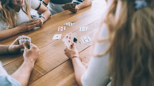 Family sitting around table playing cards