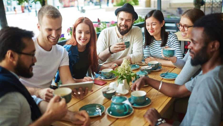 Group of people sitting at a table drinking coffee together