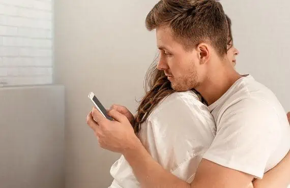 guy with partner and texting his