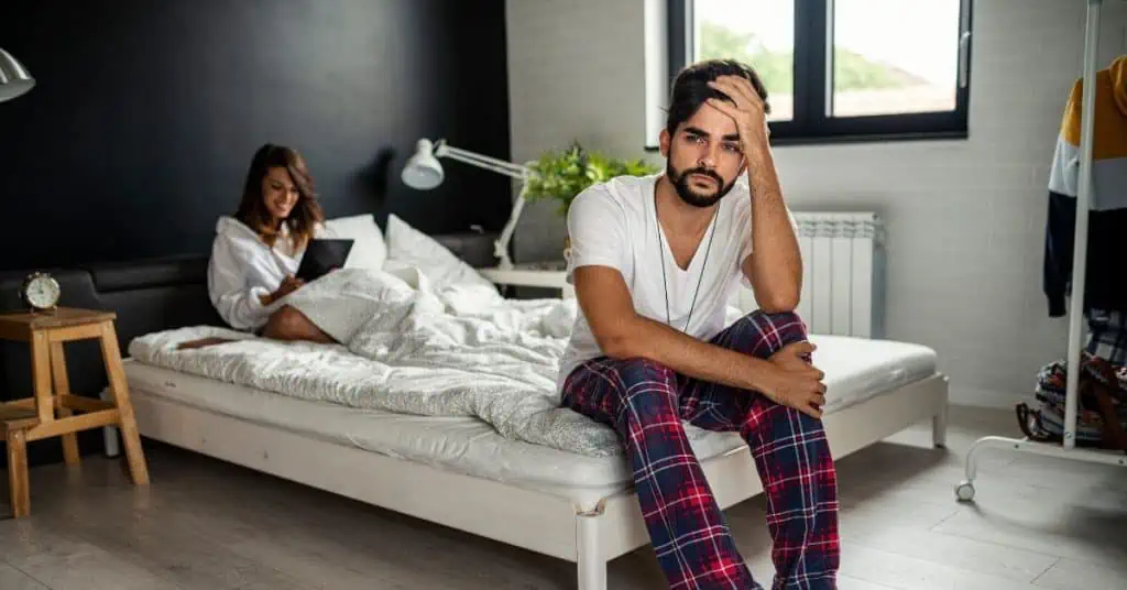 Man sitting at the edge of partners bed wondering if he is in an entanglement