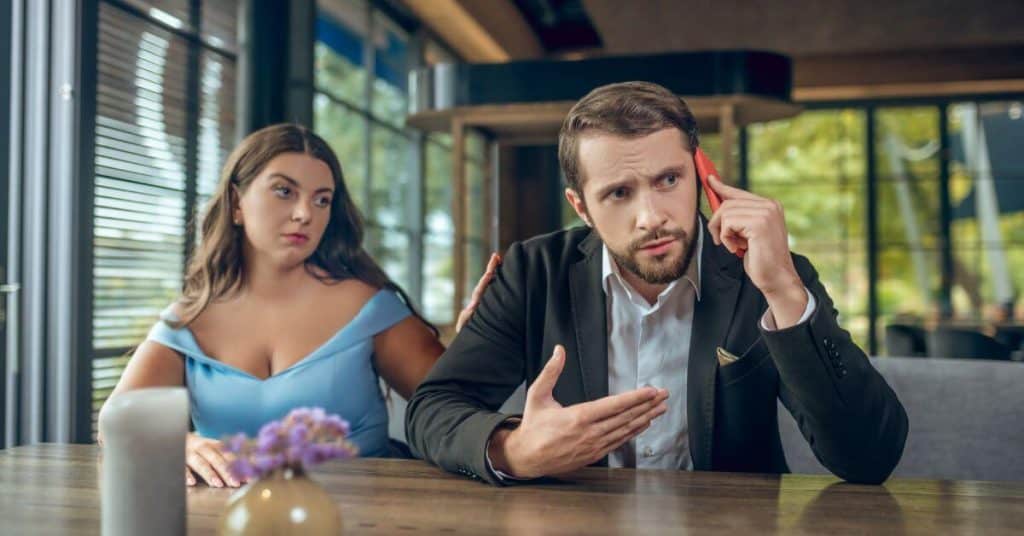 Man ignoring his date while on his phone