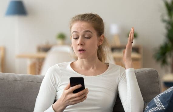 woman looking at her phone annoyed