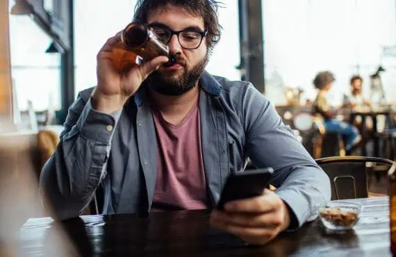 Man spending time alone at restuarant on his phone