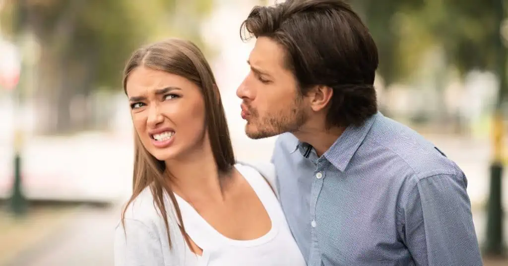 man trying to kiss woman