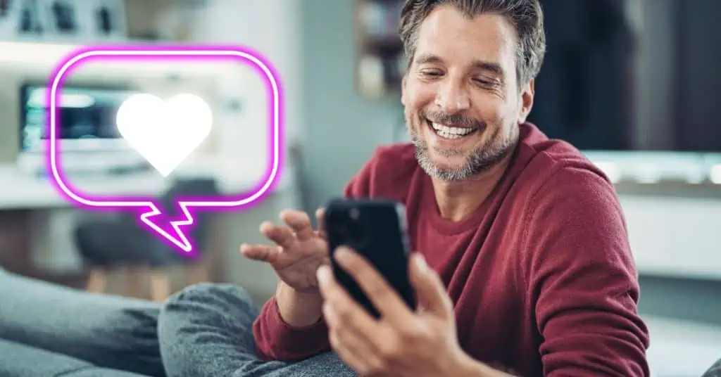 man looking at phone with glow message bubble with heart inside