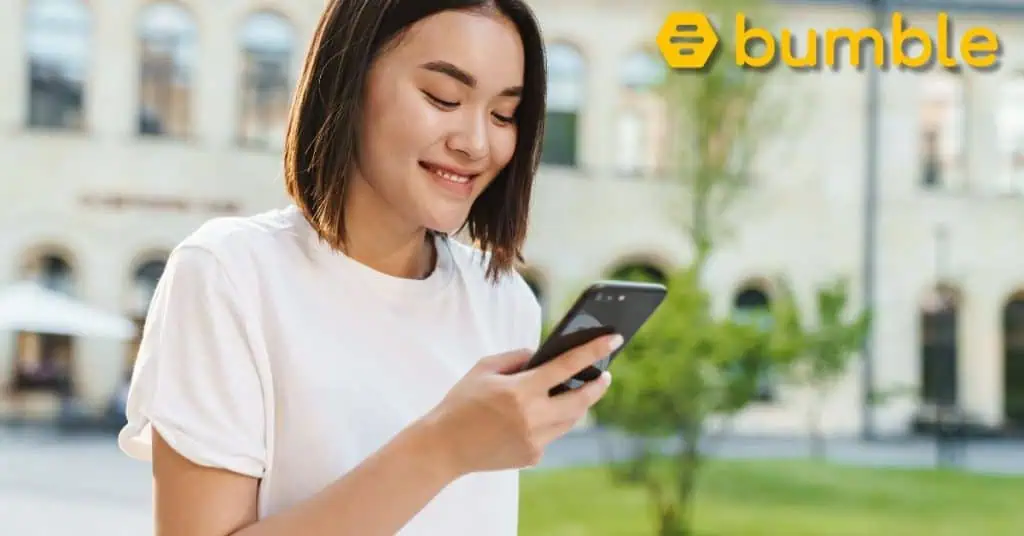 Happy Young Asian Woman Using Phone - Bumble Logo