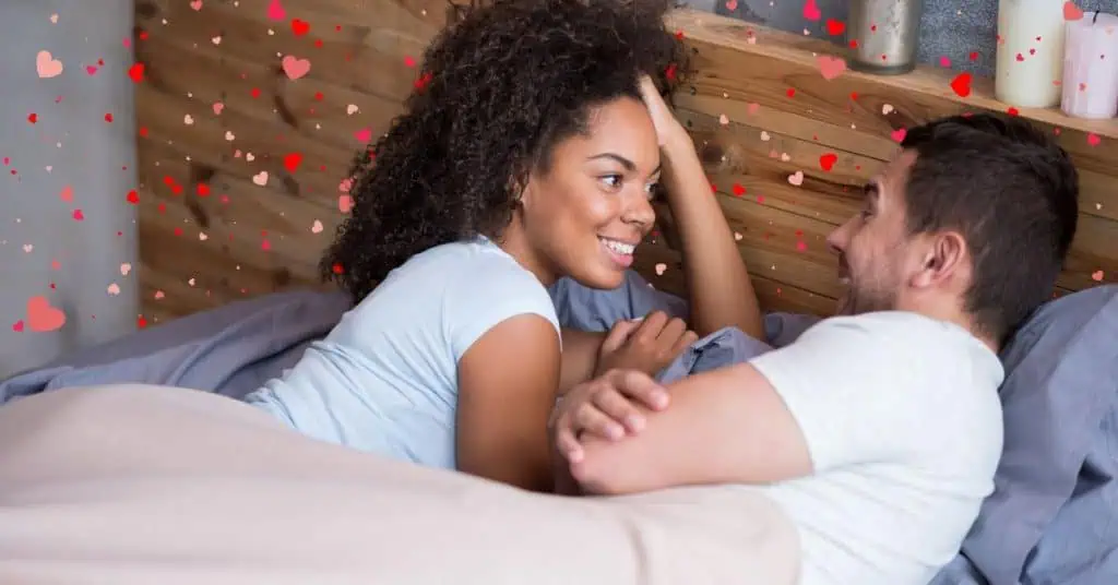 married couple in bed talking with hearts around them