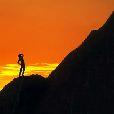 Life Challenges - Man Silhouette Looking up at the Top of a Mountain Life Challenges - Man Silhouette Looking up at the Top of a Mountain